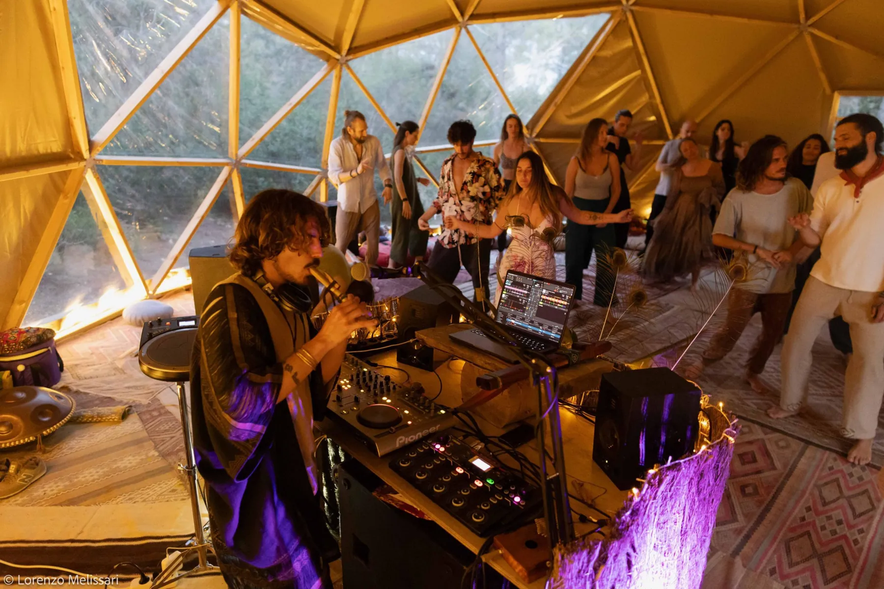 Jasileo playing flute in a dome while people dance